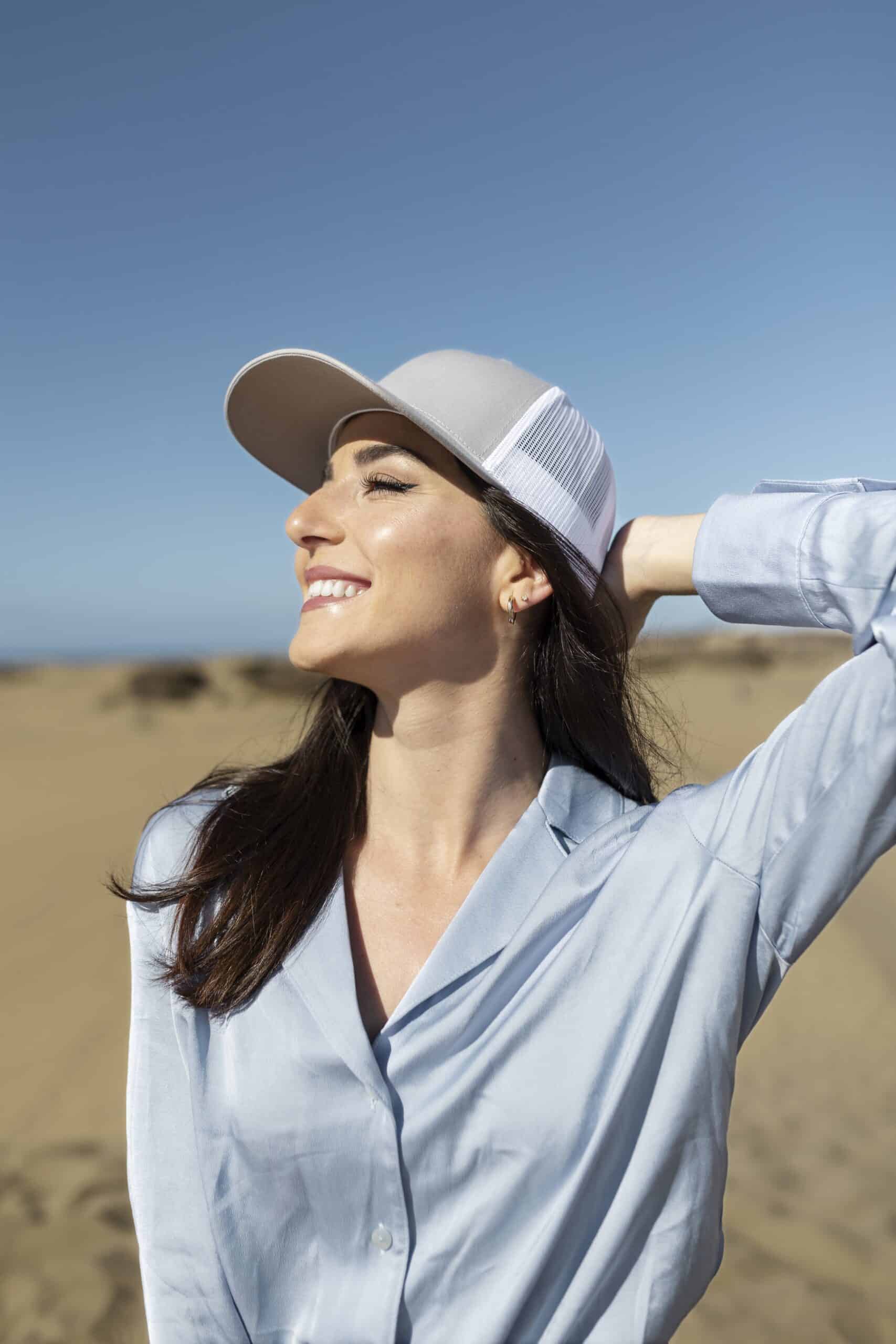 medium-shot-smiley-woman-posing-with-trucker-hat